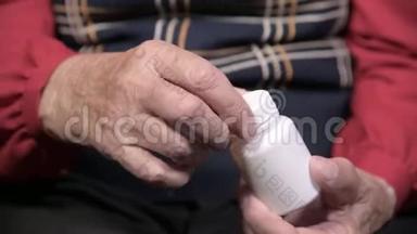 一位老妇人的手<strong>打开一个</strong>白色罐子，里面有欧米茄-3药物胶囊和维生素。 健康<strong>概念</strong>补充剂
